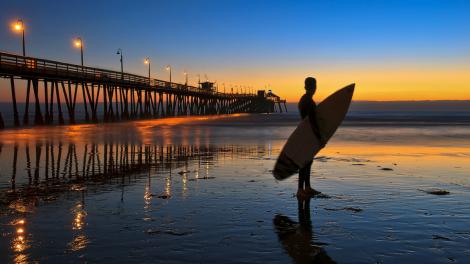 黄昏时分在圣地亚哥南部皇家海滩码头附近的太平洋享受冲浪之趣