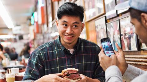 在纽约市著名的 Katz's Delicatessen 熟食店内咬一口美味的三明治