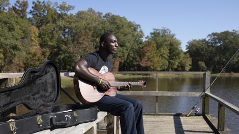 Cedric Burnside 钓鱼间隙在密西西比州杰克逊弹奏吉他