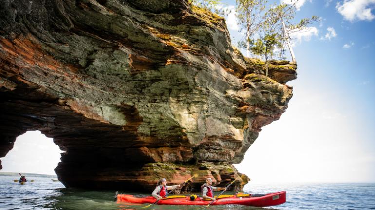 乘皮划艇穿过威斯康星州阿波斯特尔群岛国家湖滨区的海蚀洞