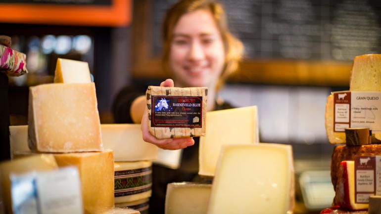 在威斯康星州麦迪逊的 Fromagination 区一位女士拿着奶酪块