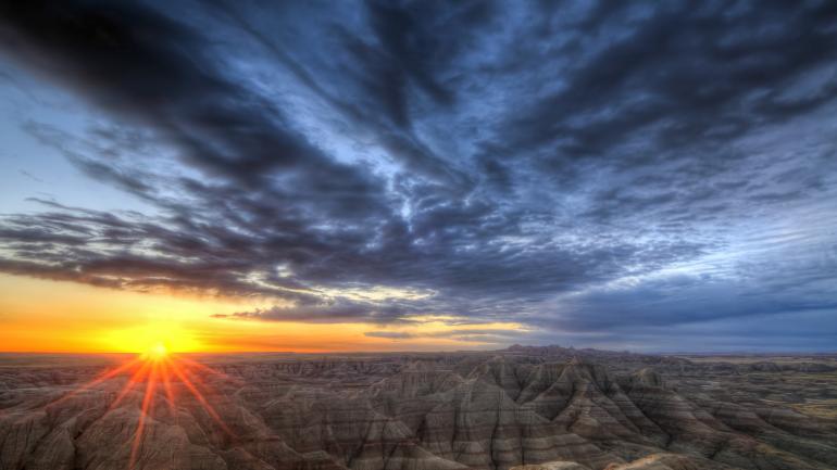 天空的景象引人注目，南达科他州恶土国家公园的侵蚀地貌壮美无比，两者交相辉映，令人震撼。