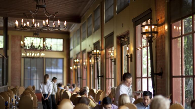 Bajo el brillo tenue de los candelabros, los meseros sirven auténtica comida mexicana en el exclusivo Hugo's en Houston