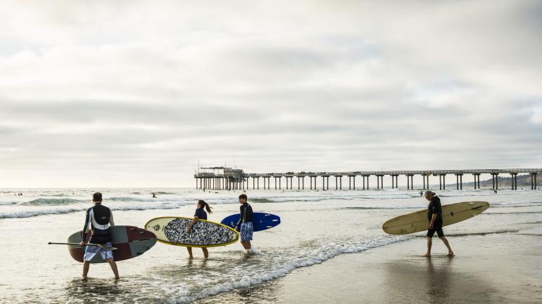 샌디에이고 스크립스 피어(Scripps Pier)에서 서퍼와 패들보더들이 바다를 향해 달려가는 모습을 구경하세요. 서퍼들의 파도타기를 볼 수 있는 것도 해안에서 즐기는 식사의 묘미입니다.