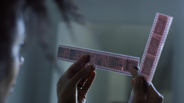 Bee Walker looking at film from one of her photography shoots