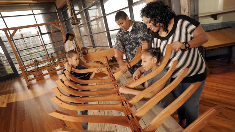 A family enjoys a hands-on exhibit at the Frederick Douglass Isaac Myers Maritime Park 