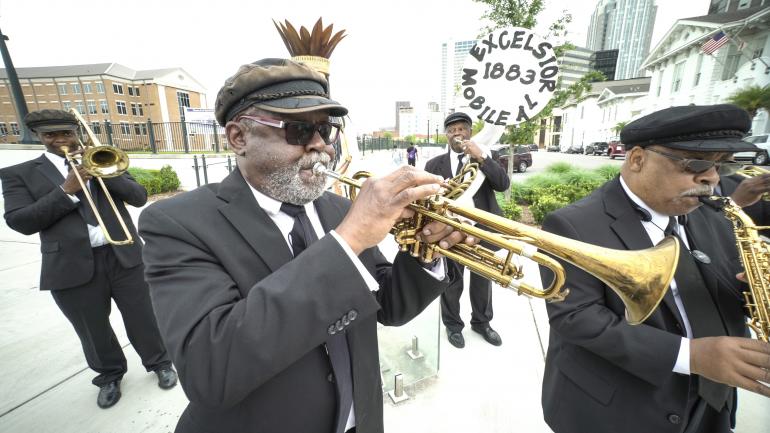 Los miembros de Excelsior Band, un clásico del Mardi Gras, presentándose en Mobile