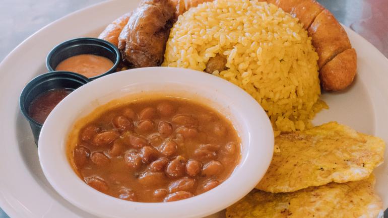传统 Longaniza 香肠搭配 Tostones（油炸大焦片）、青豆和米饭