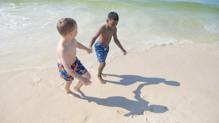 Niños jugando en las suave y blanca arena de Gulf State Park