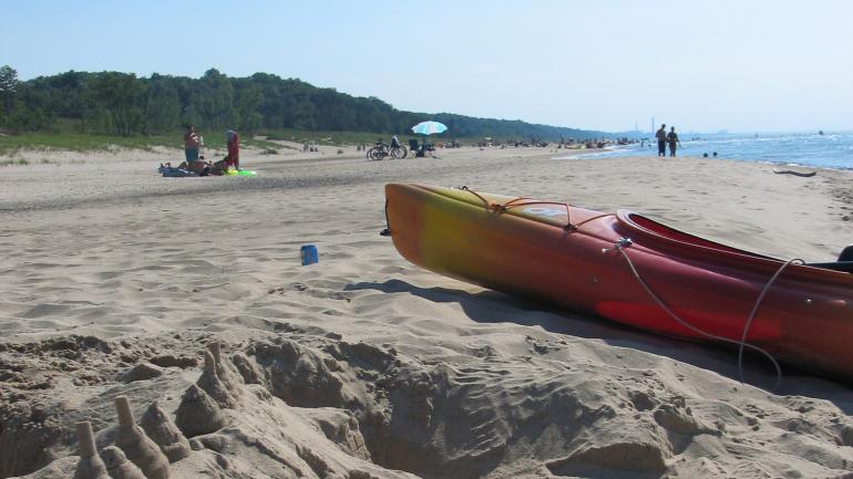 Un kayak espera a su remero en la orilla arenosa de las dunas de Indiana