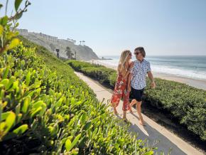 一对爱侣沿着小径漫步,从这里可以眺望盐溪海滩 一对爱侣沿着小径漫步,从这里可以眺望盐溪海滩