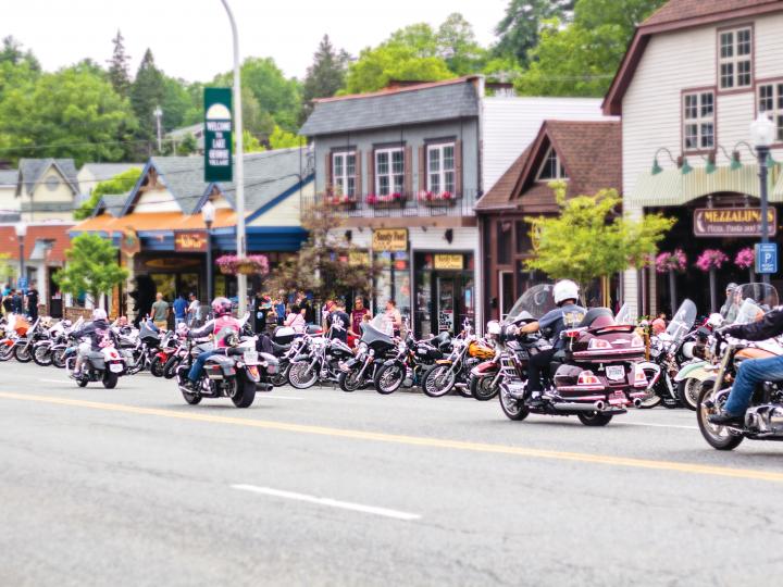 参加 Americade 摩托车拉力赛的摩托车手穿过乔治湖村