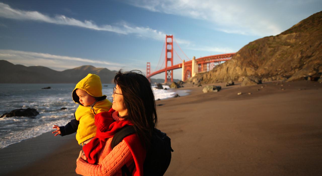 Madre e hijo en la playa, bajo el Golden Gate Bridge en San Francisco, California