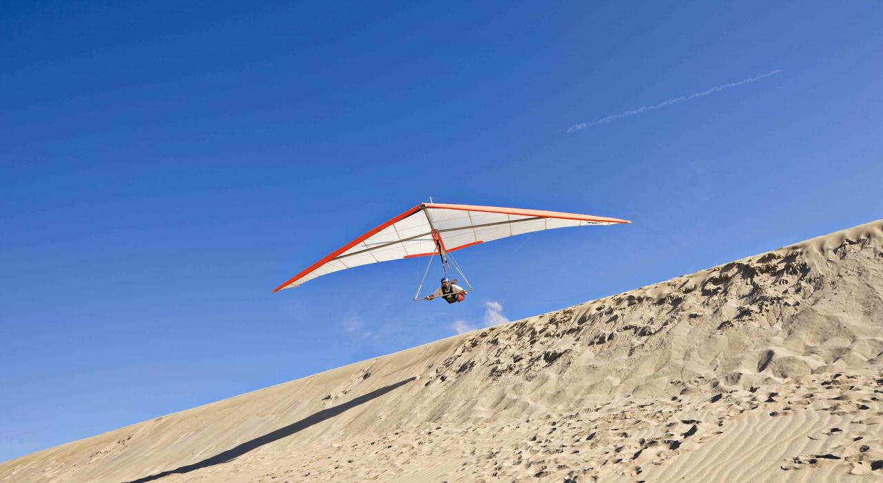 在北卡罗来纳州纳格斯赫德赛马岭州立公园 30 米高的沙丘上空滑翔