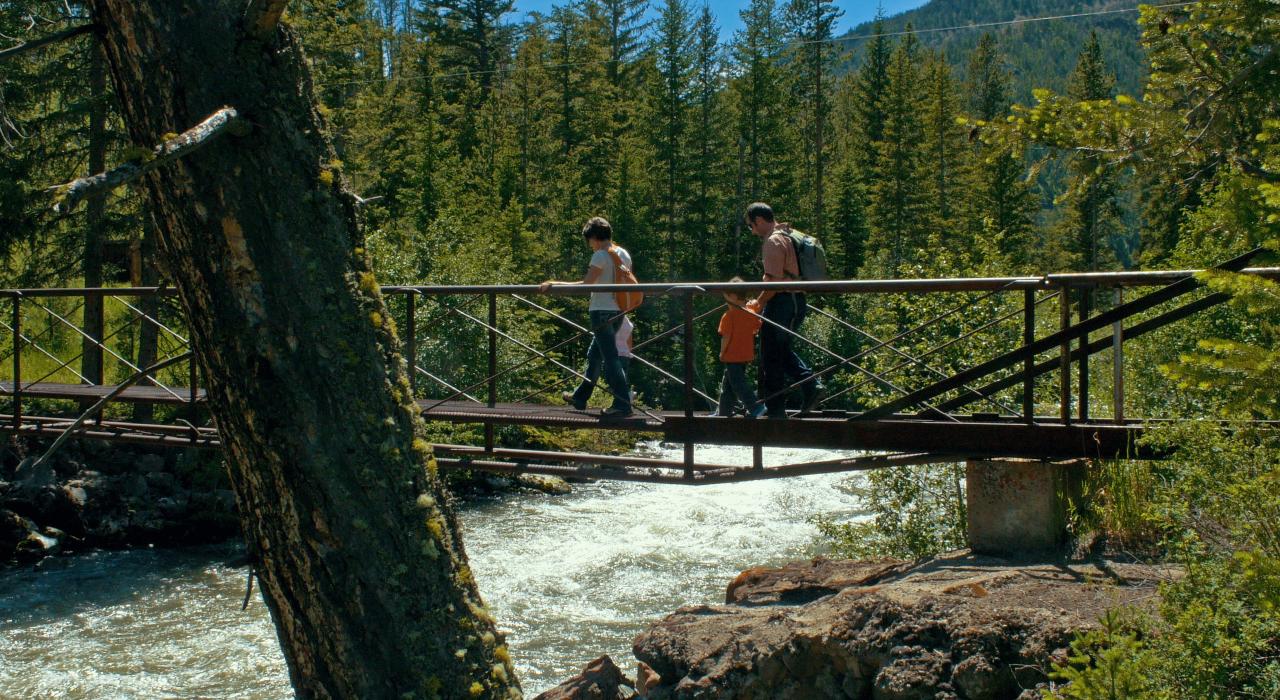 在徒步旅行的路上过桥的一家人