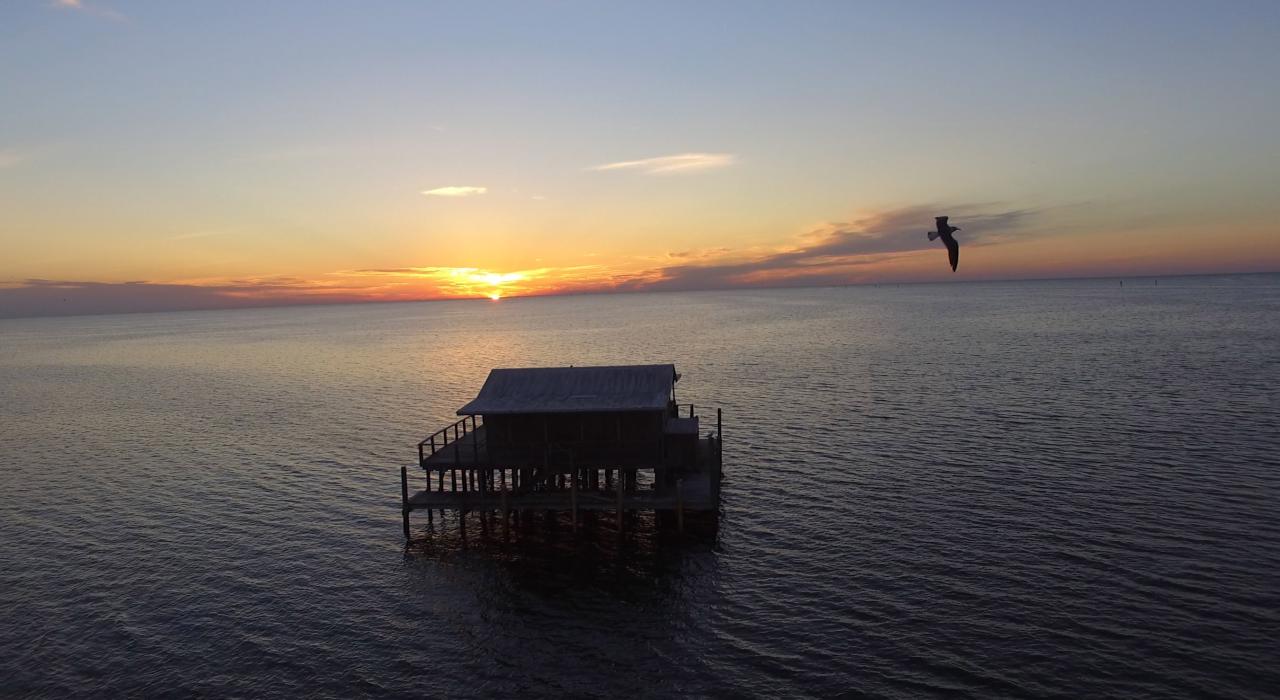 Sunset framing a stilt house over the Gulf of Mexico