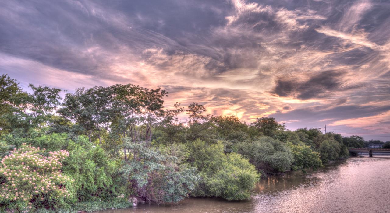 落日中阿肯色河两岸的绿树