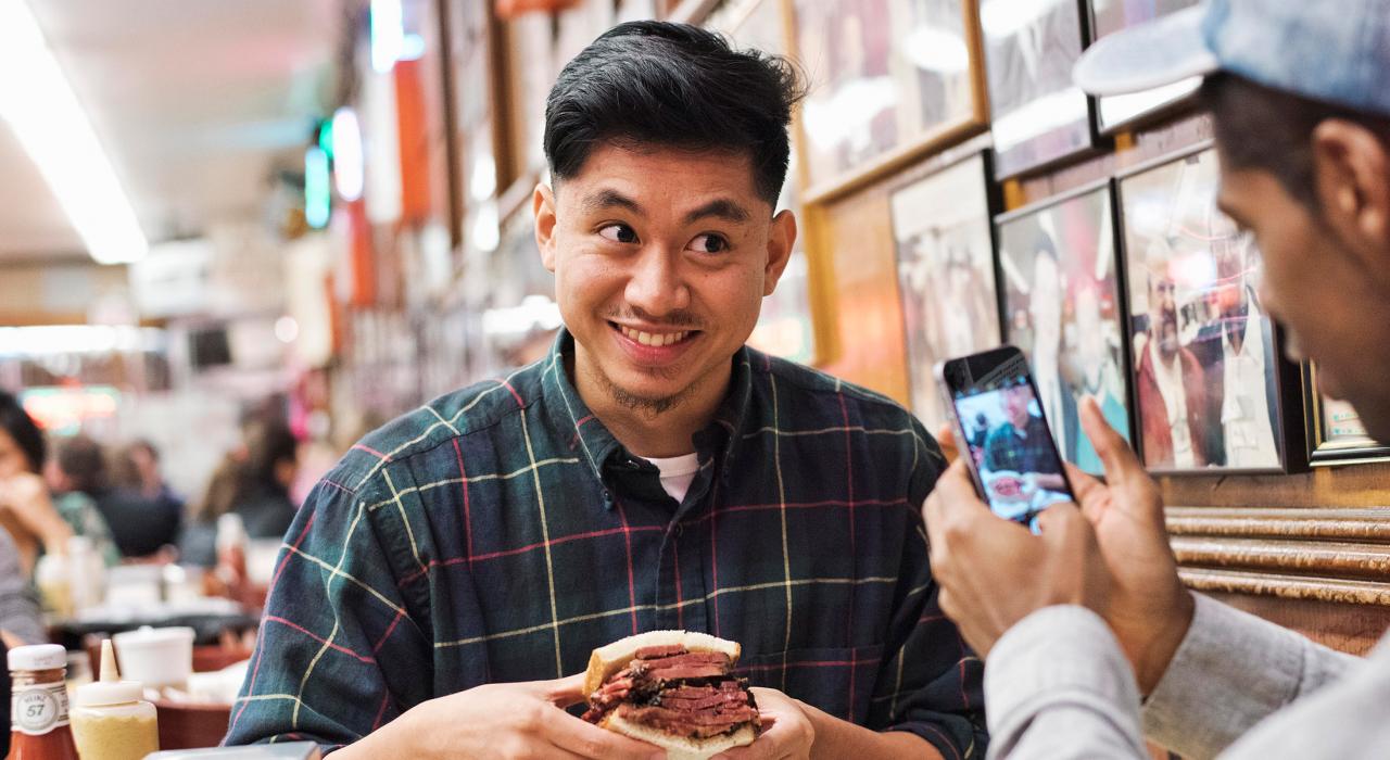 在纽约市著名的 Katz's Delicatessen 熟食店内咬一口美味的三明治