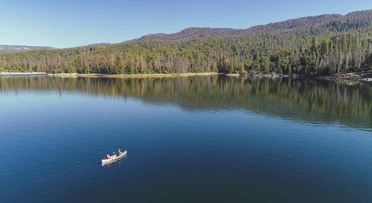 在加利福尼亚州马德拉县赛拉国家森林的巴斯湖上划独木舟