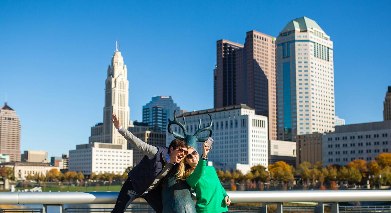 Posing with the deer sculpture in front of the city skyline on the Scioto Mile
