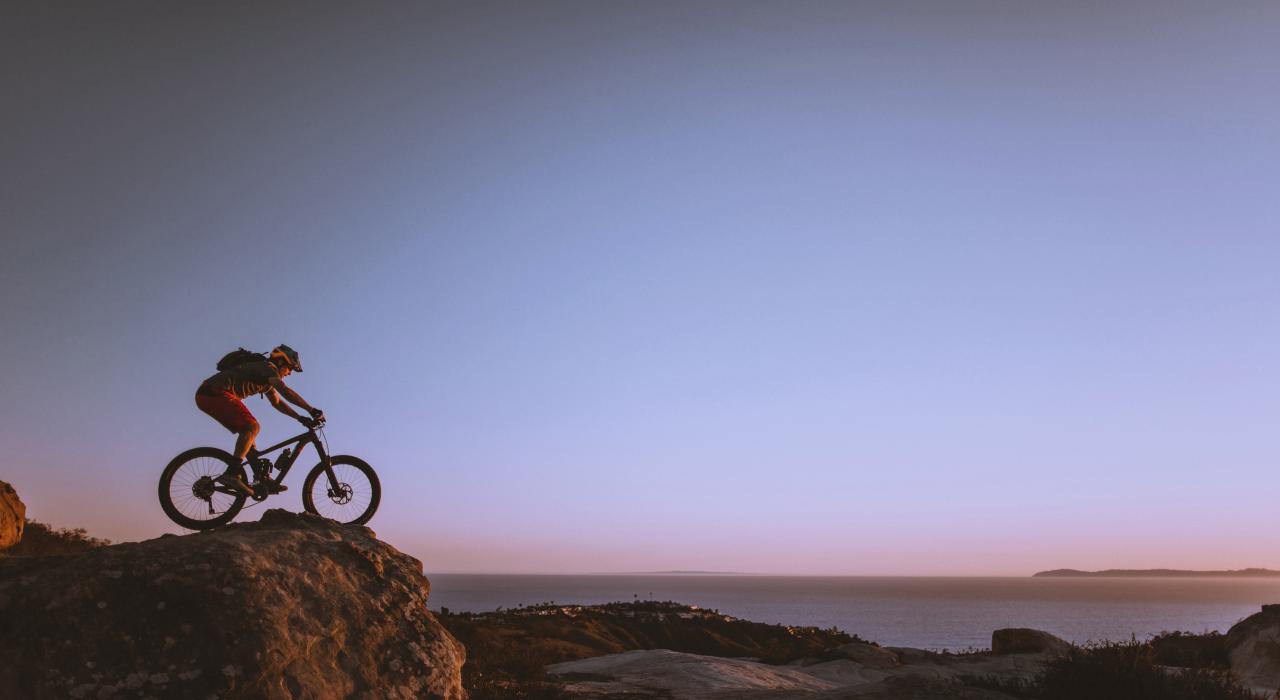 一位山地自行车骑行者从“世界之巅”观景台俯瞰着海岸