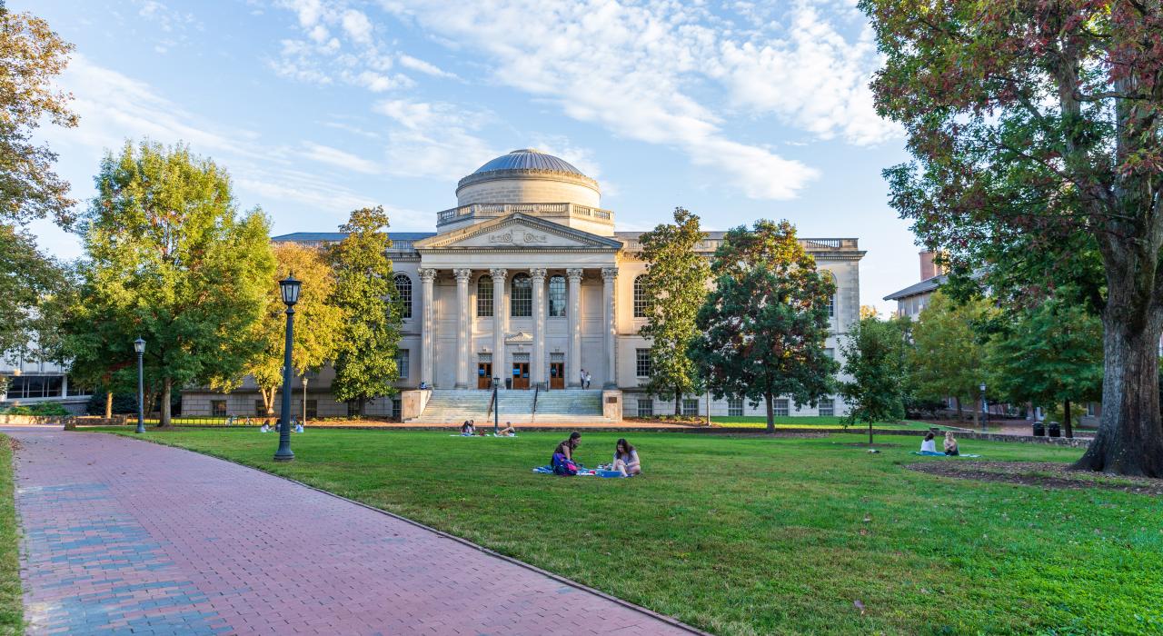 Estudiantes relajándose en el césped en la University of North Carolina Chapel Hill